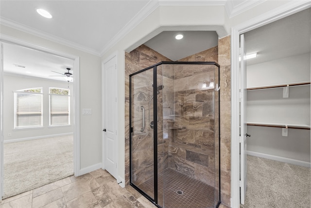 bathroom with ceiling fan, a shower with shower door, and ornamental molding