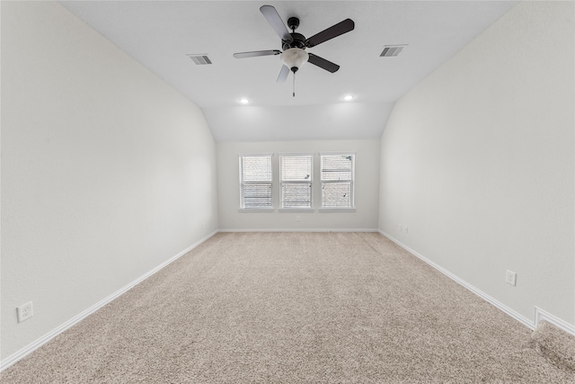 spare room featuring ceiling fan, light colored carpet, and lofted ceiling