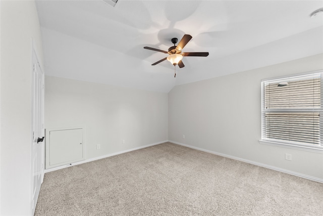 spare room with light carpet, ceiling fan, and vaulted ceiling