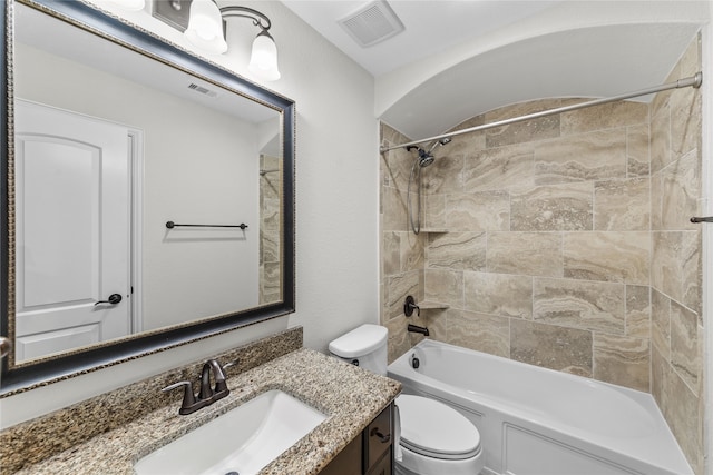 full bathroom with vanity, tiled shower / bath combo, and toilet