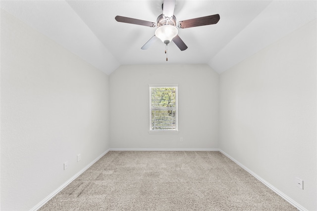 carpeted empty room featuring vaulted ceiling and ceiling fan