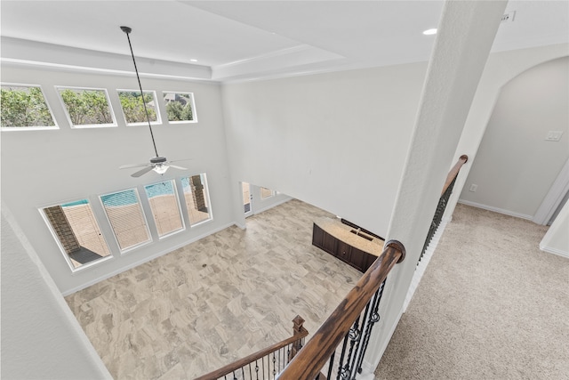 interior space featuring carpet, ceiling fan, and a tray ceiling