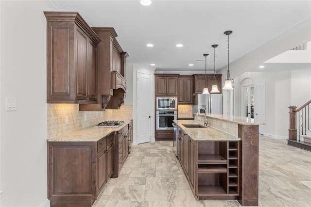 kitchen with appliances with stainless steel finishes, dark brown cabinetry, a spacious island, sink, and pendant lighting