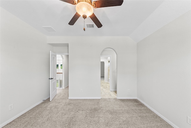 carpeted empty room with vaulted ceiling and ceiling fan