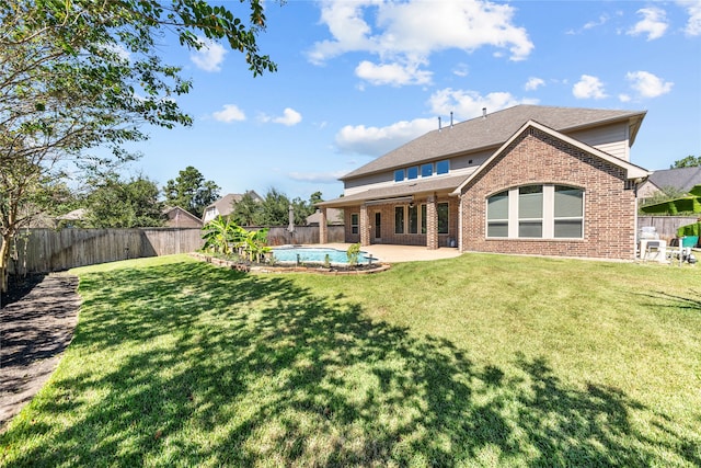 back of house with a lawn, a patio area, and a fenced in pool