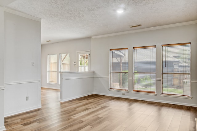 unfurnished room with a textured ceiling, light hardwood / wood-style flooring, and ornamental molding