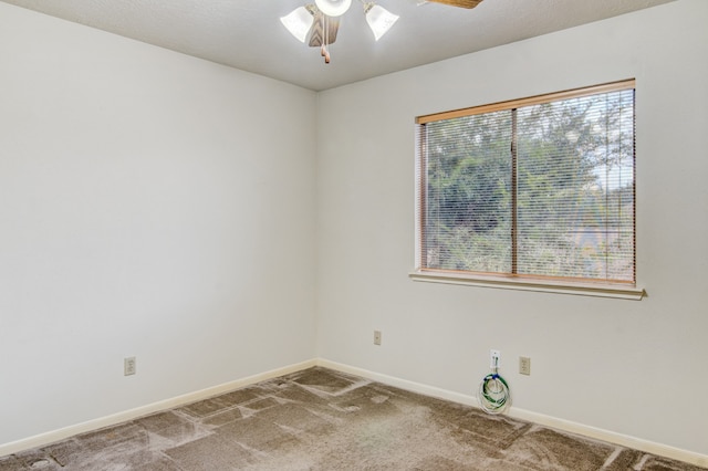 carpeted spare room featuring plenty of natural light and ceiling fan