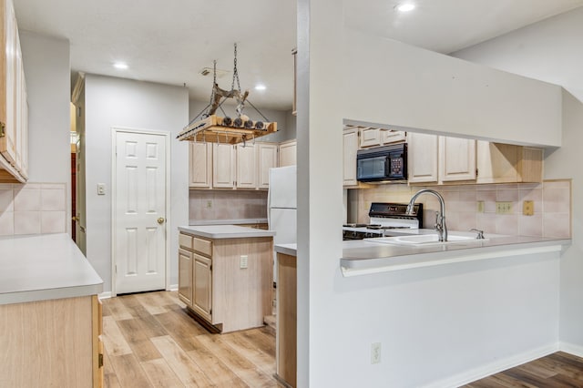 kitchen featuring decorative backsplash, light hardwood / wood-style flooring, gas range, and sink