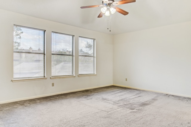 carpeted empty room featuring ceiling fan and a healthy amount of sunlight