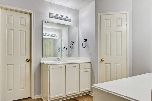 bathroom featuring a textured ceiling, vanity, and hardwood / wood-style flooring