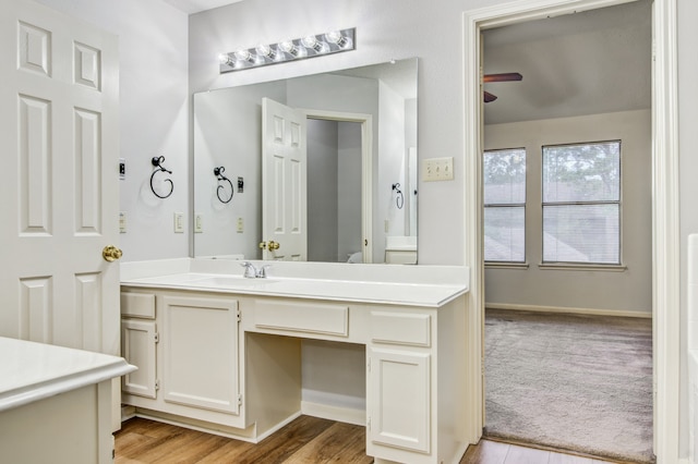 bathroom with hardwood / wood-style floors, ceiling fan, and vanity