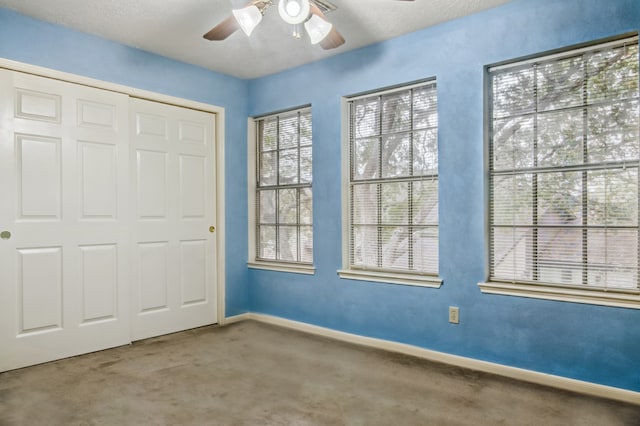 interior space featuring ceiling fan, a textured ceiling, a closet, and carpet floors