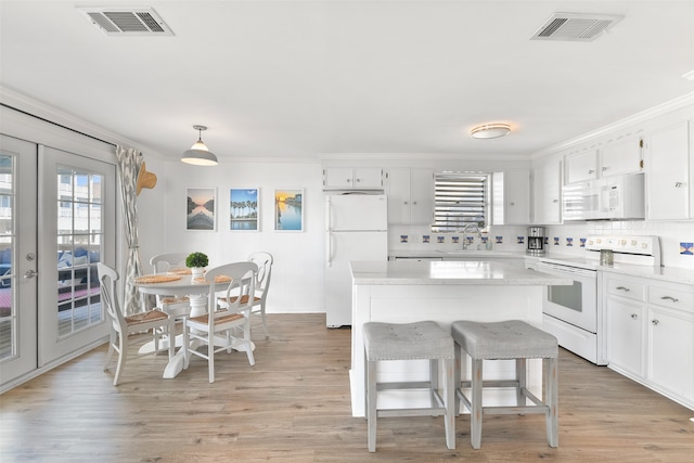 kitchen featuring decorative light fixtures, white appliances, french doors, and white cabinets