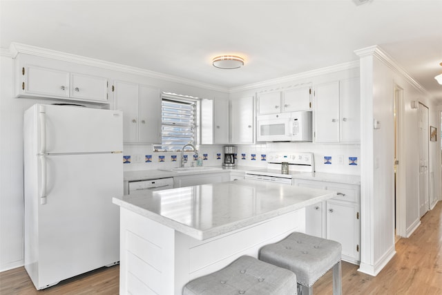 kitchen with white appliances, sink, light hardwood / wood-style flooring, and a center island