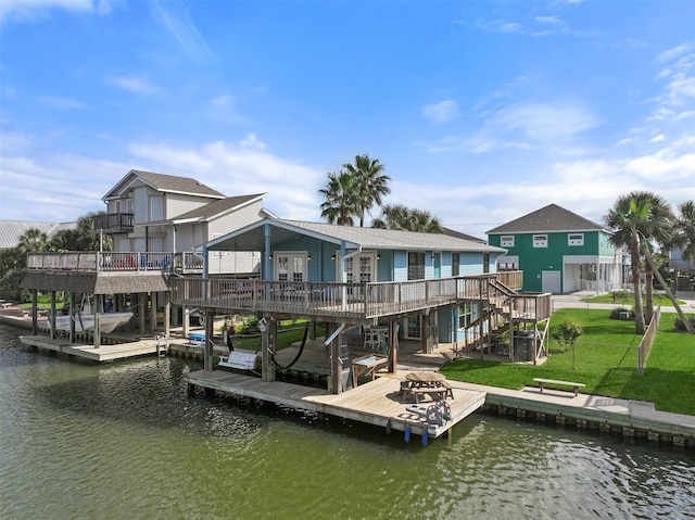 back of property featuring a deck with water view and a lawn