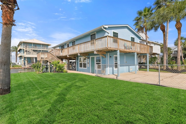 back of property with a deck, a patio, and a yard