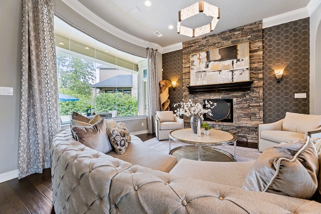 living room featuring a stone fireplace, wood-type flooring, and ornamental molding