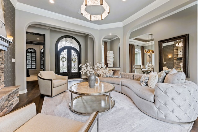 living room featuring hardwood / wood-style flooring, a notable chandelier, ornamental molding, and french doors