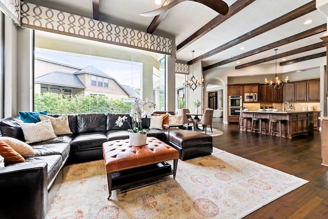 living room with sink, dark hardwood / wood-style flooring, beamed ceiling, and a notable chandelier