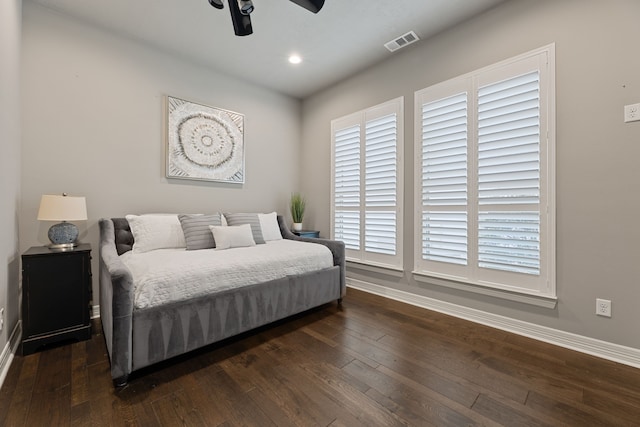 bedroom with dark hardwood / wood-style flooring and ceiling fan