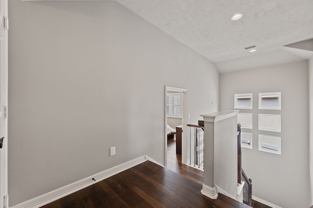 interior space with dark hardwood / wood-style floors and vaulted ceiling