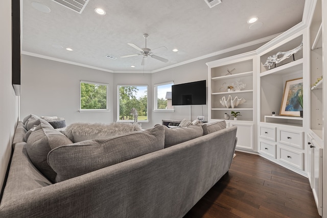 living room featuring a textured ceiling, ceiling fan, ornamental molding, and dark wood-type flooring