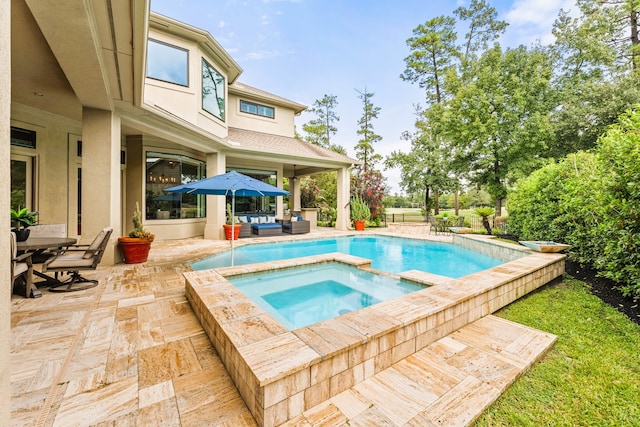 view of swimming pool featuring a patio area and an in ground hot tub