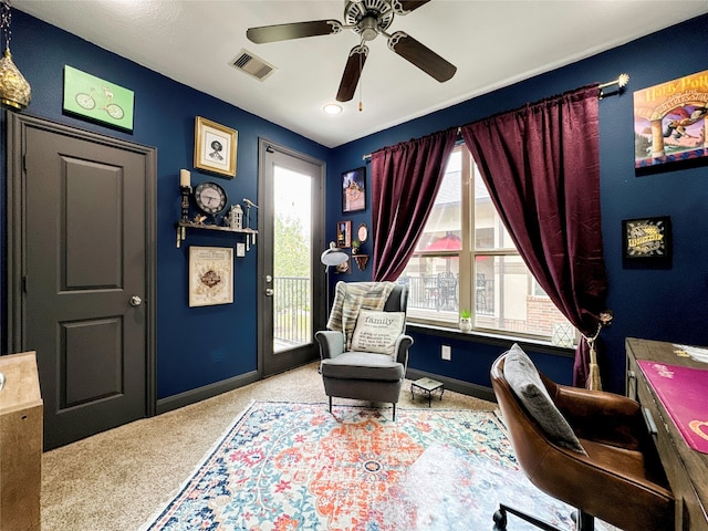 sitting room featuring a wealth of natural light, ceiling fan, and carpet flooring