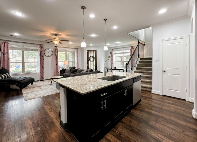 kitchen with dark wood-type flooring, a center island with sink, decorative light fixtures, sink, and dishwasher