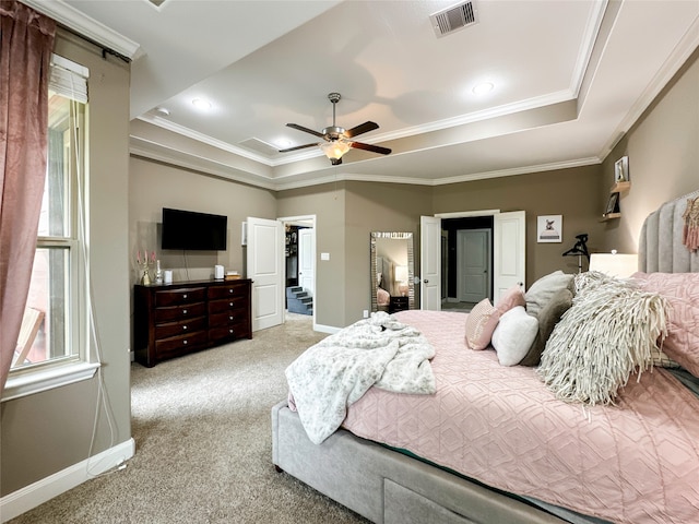 carpeted bedroom with crown molding, a spacious closet, ceiling fan, and a raised ceiling