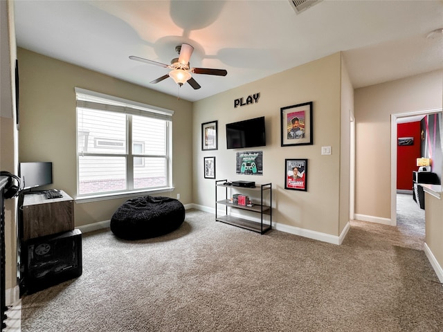 living area with light colored carpet and ceiling fan