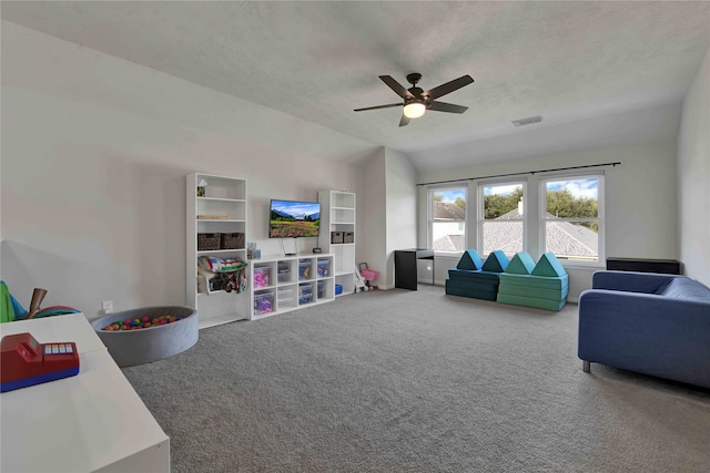 living room with carpet, vaulted ceiling, ceiling fan, and a textured ceiling