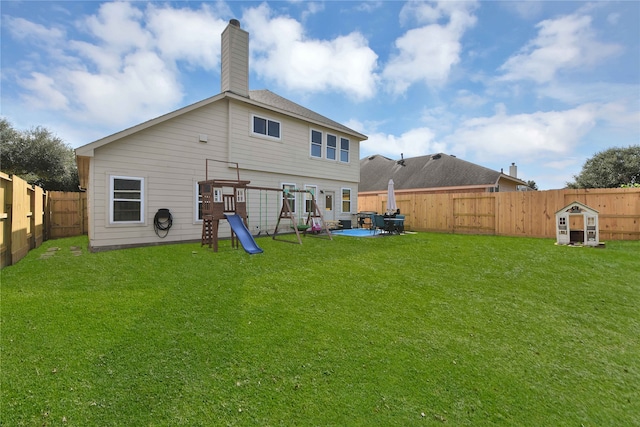 rear view of house featuring a yard