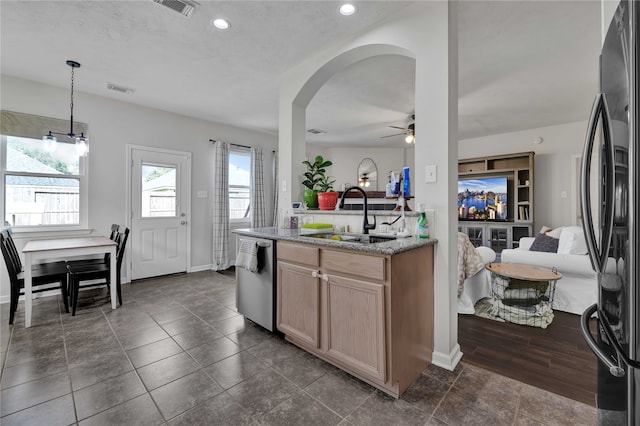 kitchen with appliances with stainless steel finishes, pendant lighting, stone counters, sink, and ceiling fan