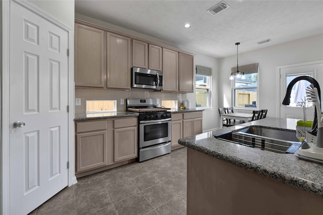 kitchen with stainless steel appliances, backsplash, pendant lighting, sink, and tile patterned flooring