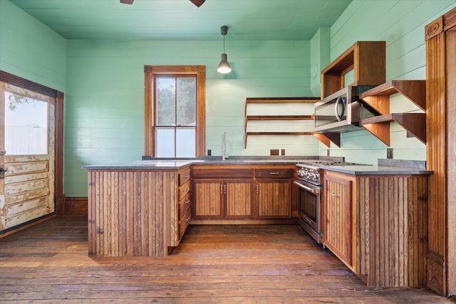 kitchen featuring appliances with stainless steel finishes, dark hardwood / wood-style floors, hanging light fixtures, sink, and kitchen peninsula