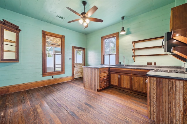 kitchen featuring dark hardwood / wood-style flooring, pendant lighting, sink, kitchen peninsula, and ceiling fan