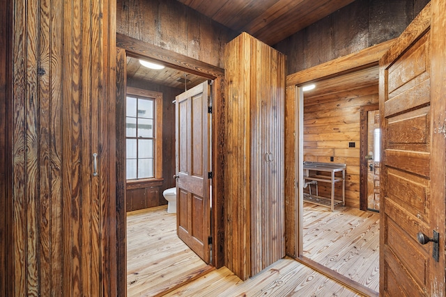 bathroom with wood walls, wooden ceiling, wood-type flooring, and toilet