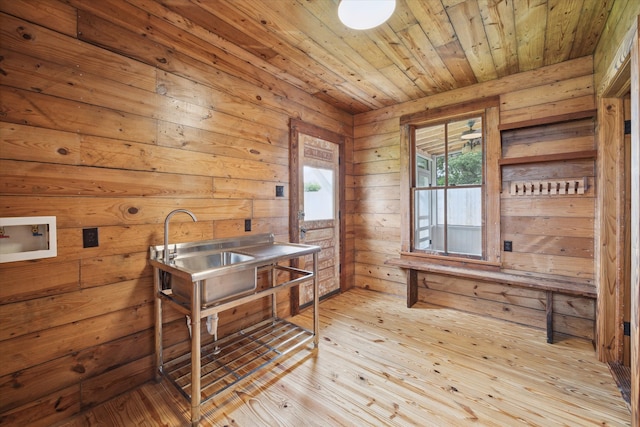 dining space featuring light wood-type flooring, wooden walls, and wooden ceiling