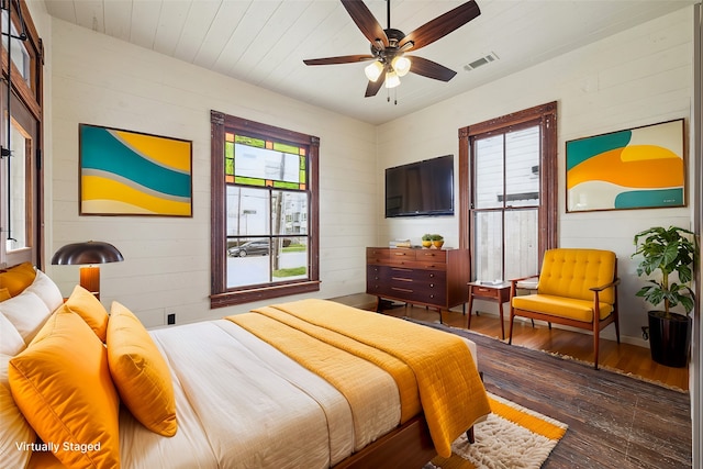 bedroom featuring dark wood-type flooring, multiple windows, and ceiling fan