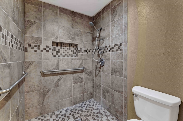 bathroom with toilet and tiled shower