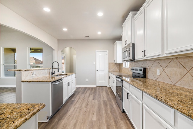 kitchen featuring light stone countertops, appliances with stainless steel finishes, and sink