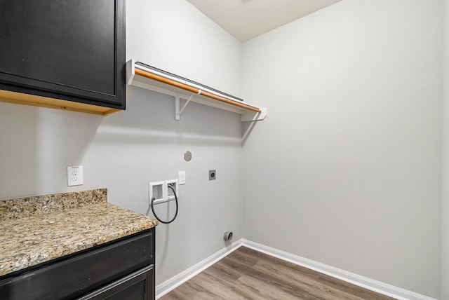 laundry area with dark wood-type flooring, hookup for a washing machine, electric dryer hookup, and cabinets