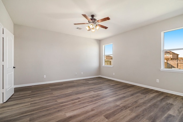 empty room featuring dark wood-type flooring and ceiling fan