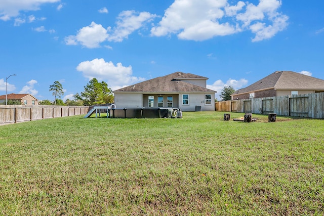 rear view of property with a yard