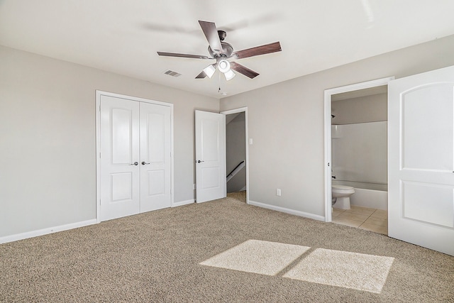 unfurnished bedroom with ensuite bathroom, light colored carpet, ceiling fan, and a closet