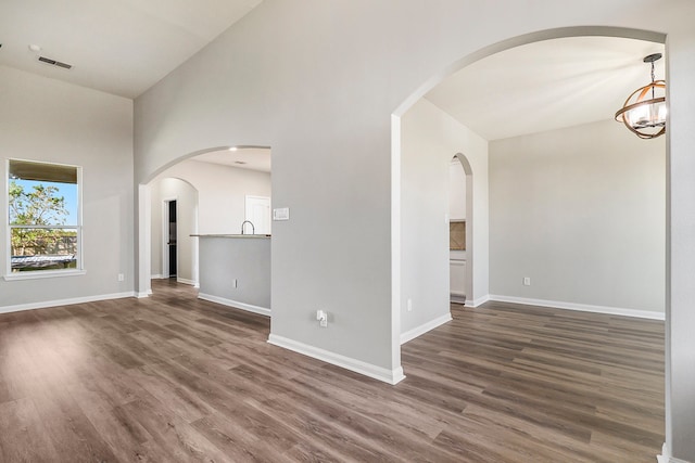 unfurnished living room featuring high vaulted ceiling, sink, and dark hardwood / wood-style flooring