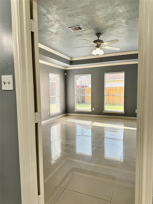 tiled spare room featuring plenty of natural light, ceiling fan, and crown molding