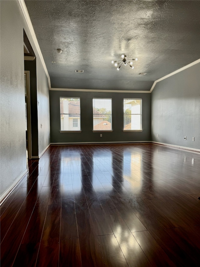 spare room with dark wood-type flooring, a wealth of natural light, and a textured ceiling