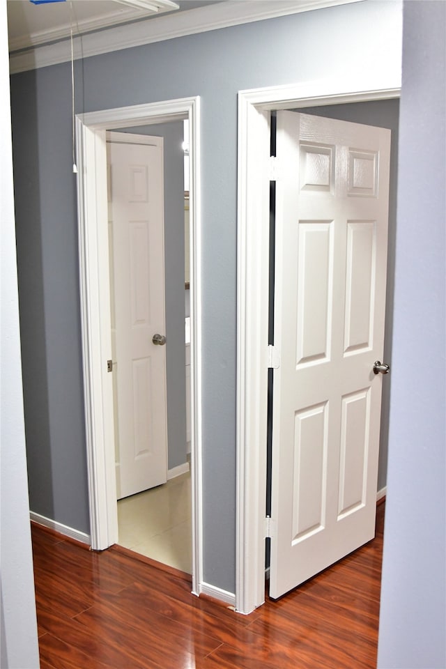 hallway with ornamental molding and dark wood-type flooring